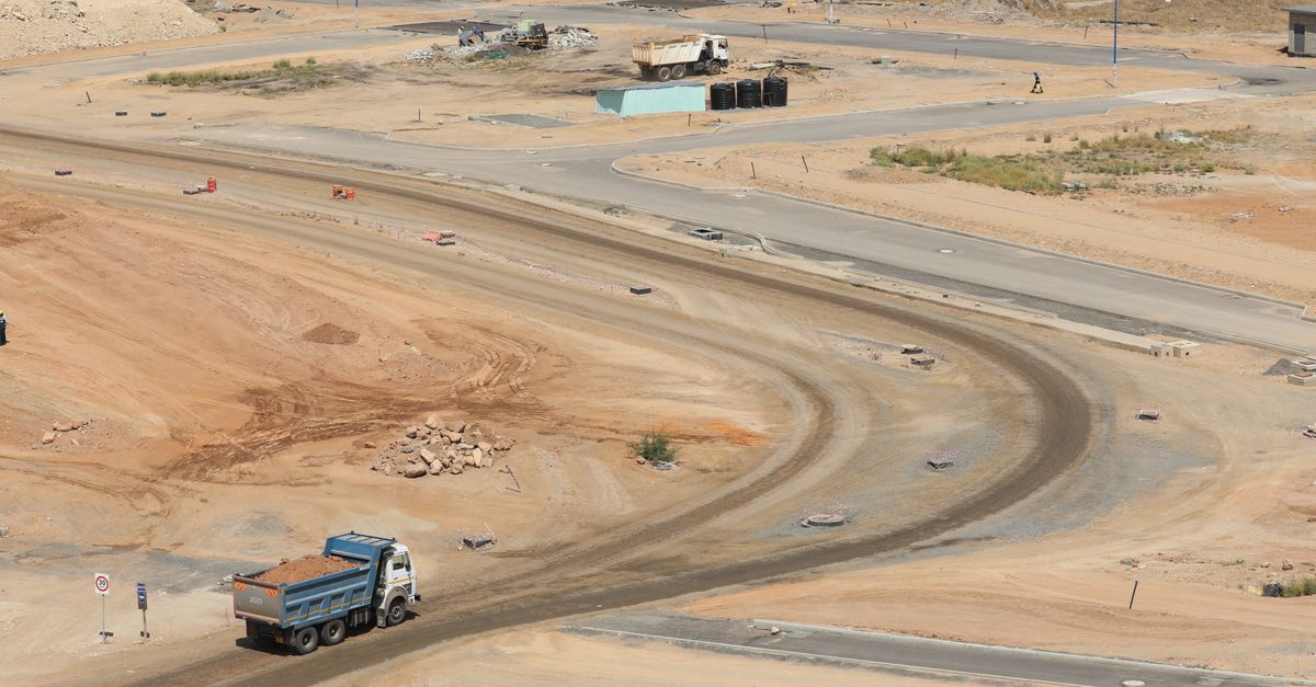 Drone shot of a developing construction site in Konza, Machakos County with dump trucks and dirt roads.