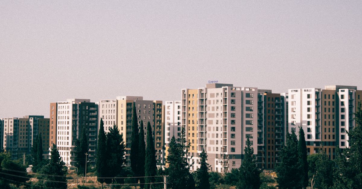 Urban residential buildings with trees and clear sky in Tbilisi.